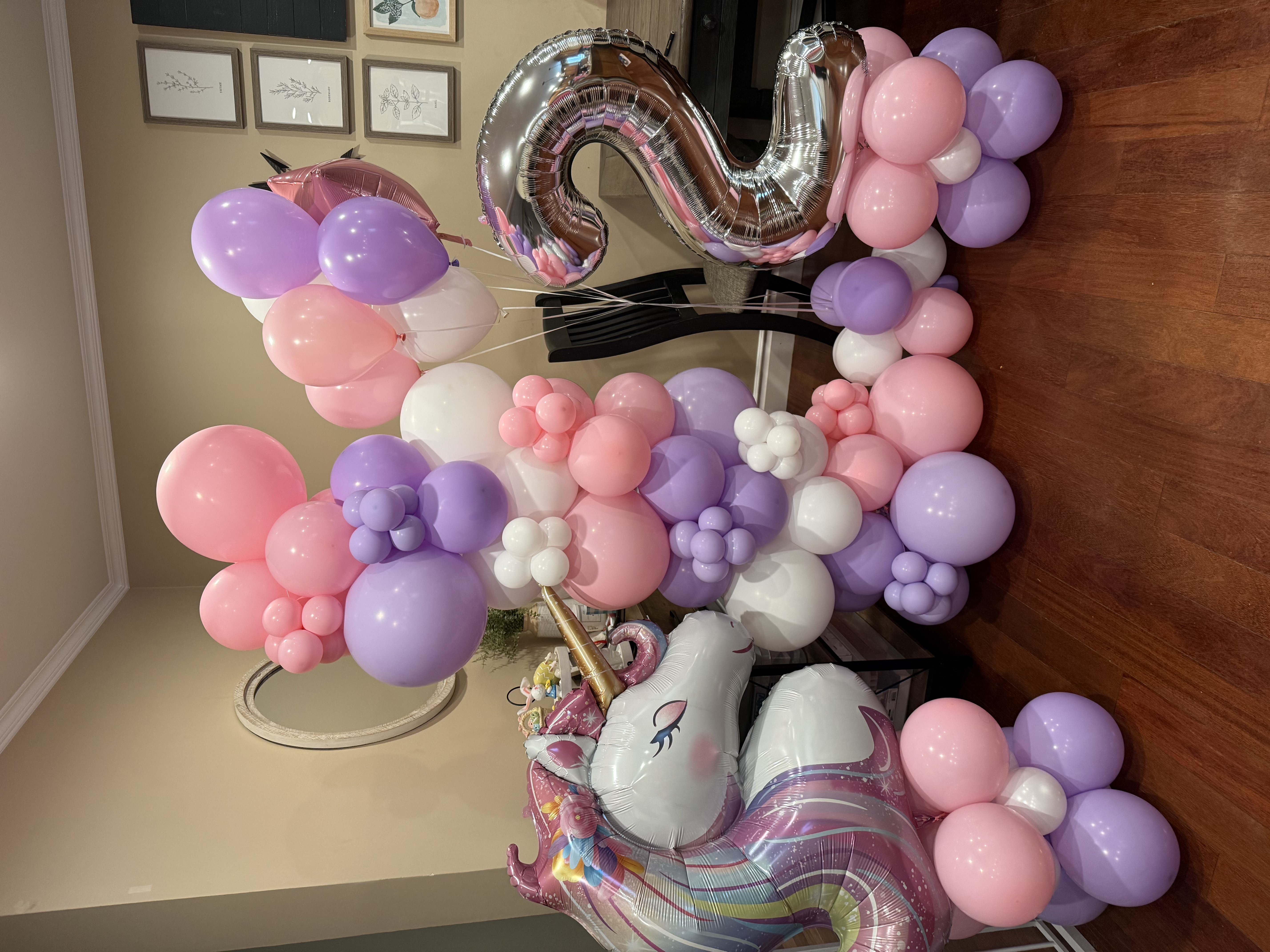 Pink, purple and white unicorn petite party setup with a number 2 balloon