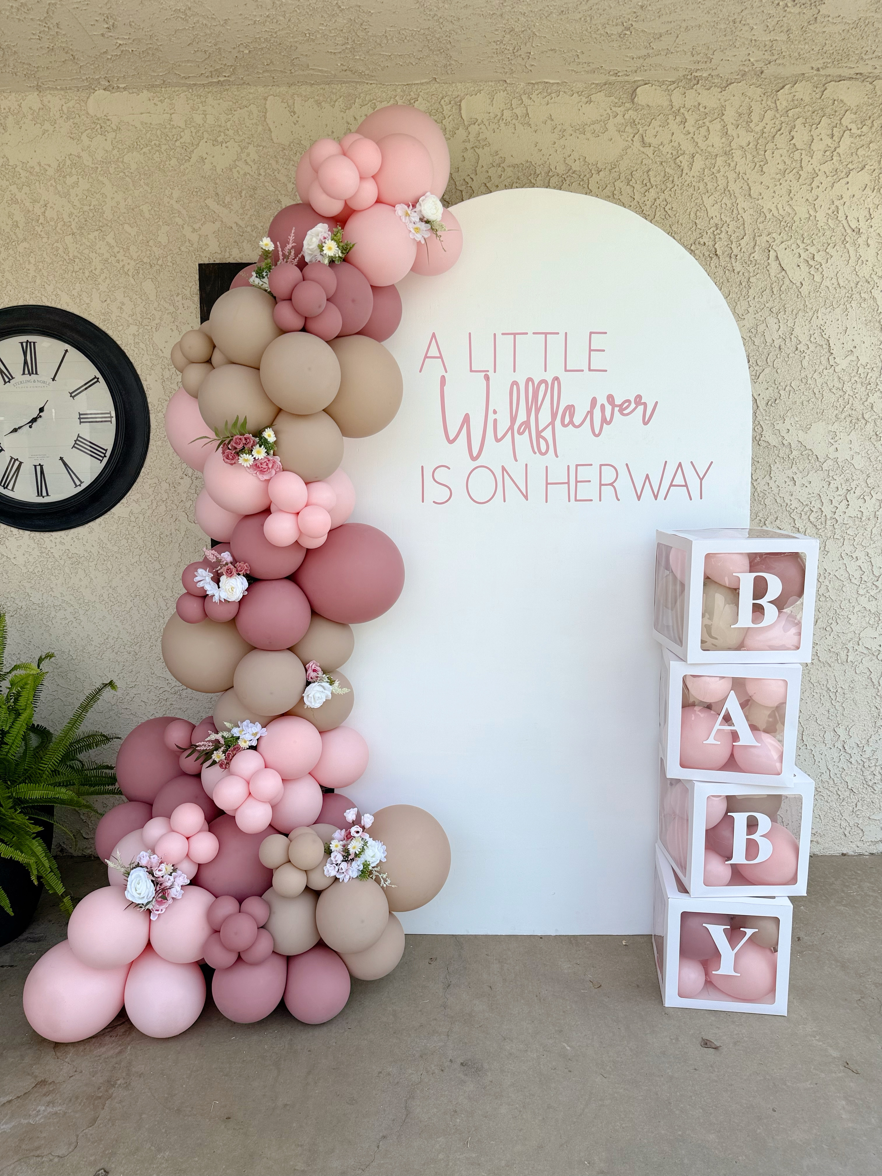 Custom 'A Little Wildflower' arch backdrop with organic garland and baby blocks